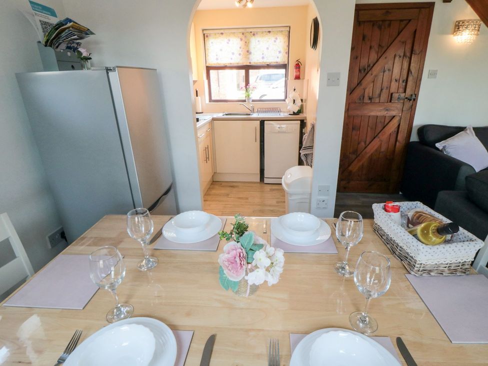 A dining room with a table set for dinner at Cha Cha's Cottage in Whitby