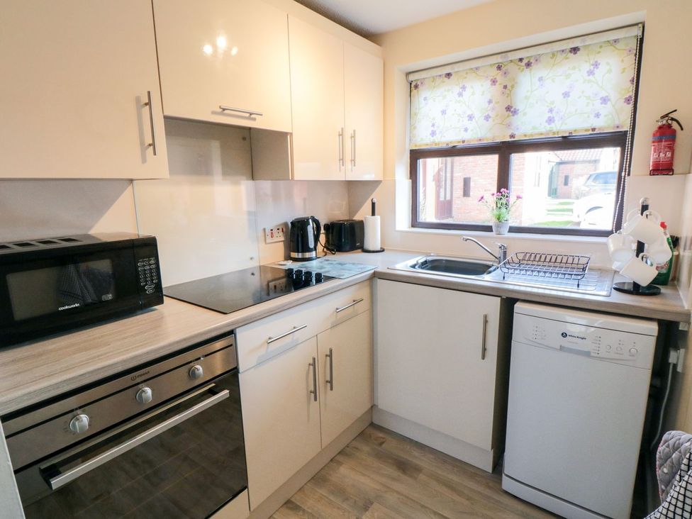 A kitchen with a sink and appliances at Cha Cha's Cottage in Whitby