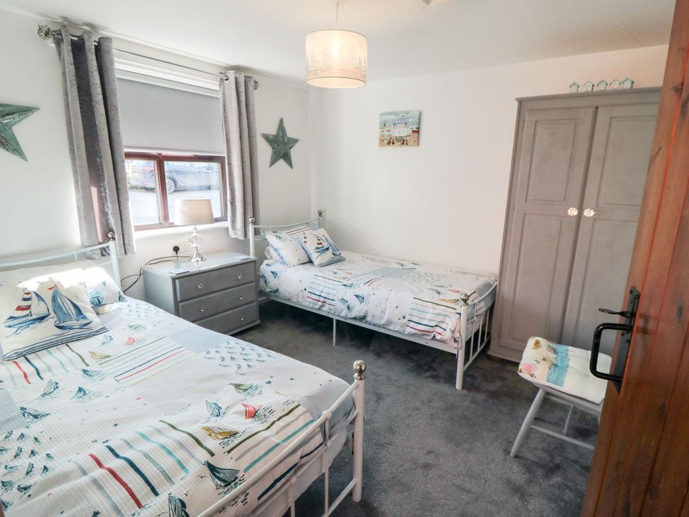 A bedroom with two beds and a chest of drawers at Cha Cha's Cottage in Whitby