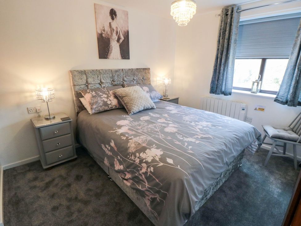 A bedroom with a bed and bedside table at Cha Cha's Cottage in Whitby