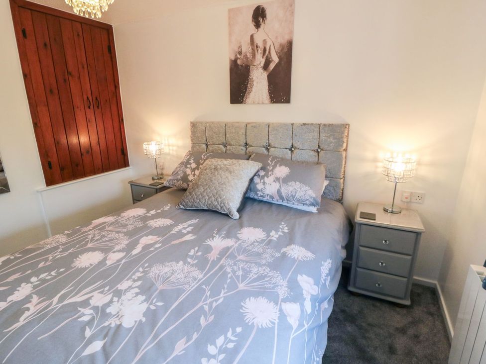 A bedroom with a bed and bedside tables at Cha Cha's Cottage in Whitby