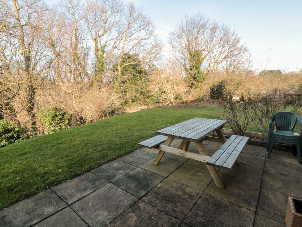 A garden with a table and benches at Cha Cha's Cottage in Whitby