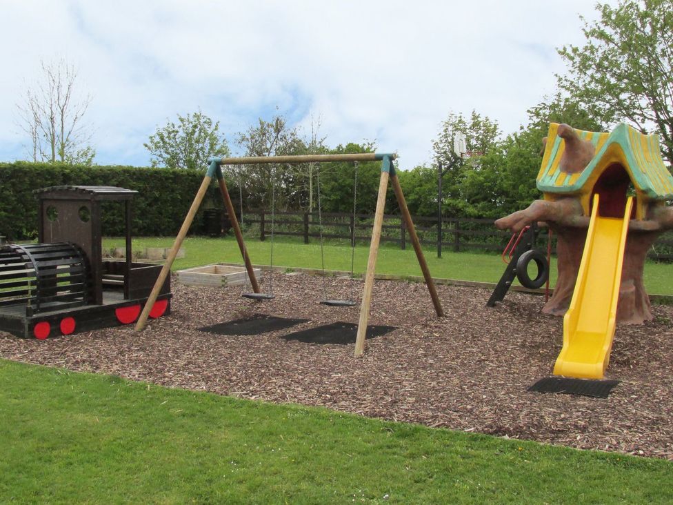 A playground with swings and a play structure at Cha Cha's Cottage Whitby