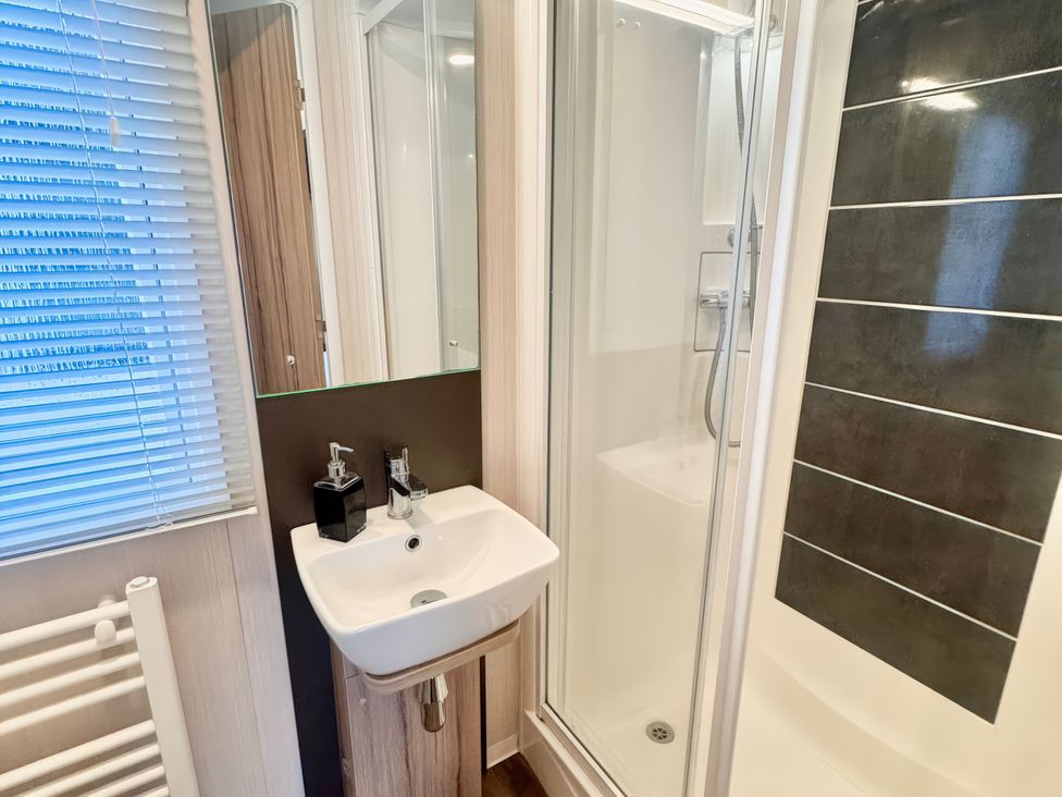 A bathroom with a sink and shower at Chappies Caravan 2.0 in Rhyl