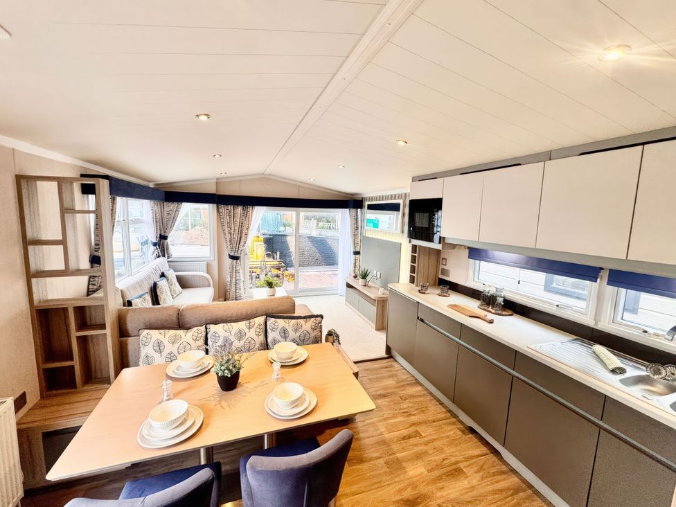A living room with a dining area and kitchen in Chappies Caravan 2.0 Rhyl