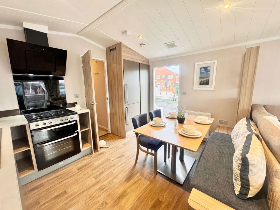 A kitchen with a dining table and chairs at Chappies Caravan 2.0 Rhyl