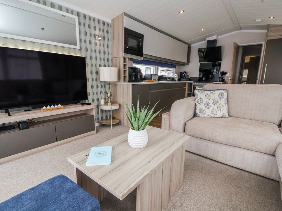 A living room with a television and a coffee table at Chappie's Caravan 2.0 Rhyl