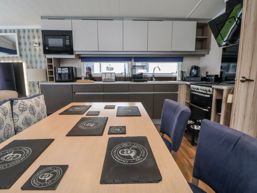 A kitchen with table and chairs at Chappie's Caravan 2.0 Rhyl