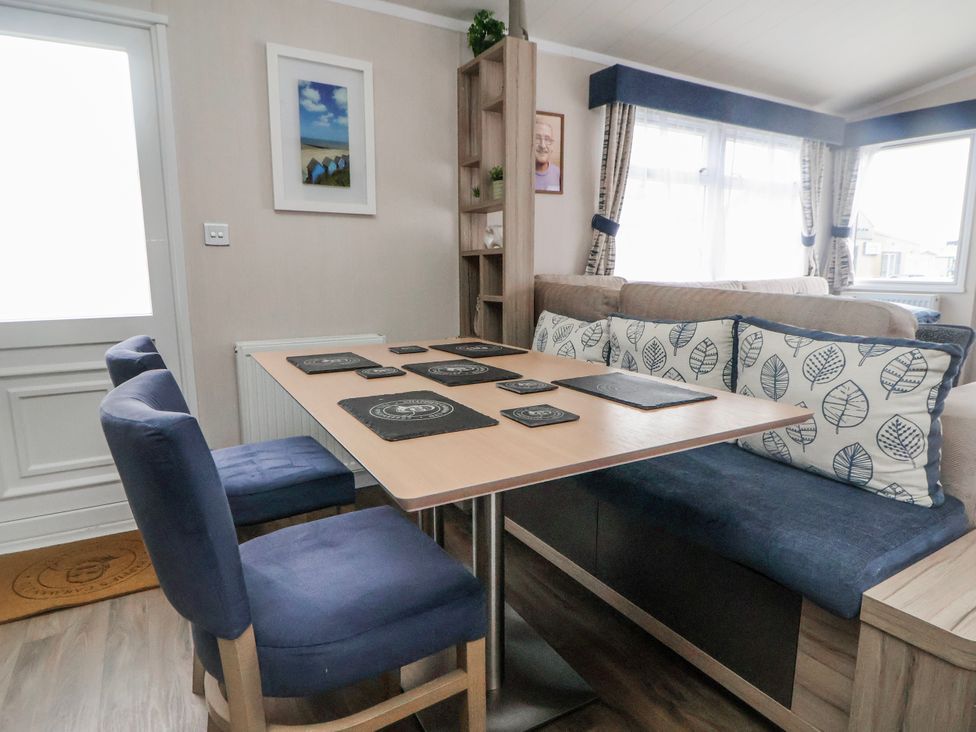 A dining area with a table and chairs at Chappie's Caravan 2.0 Rhyl