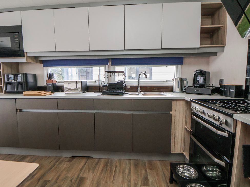 A kitchen featuring appliances and countertops at Chappie's Caravan 2.0 Rhyl