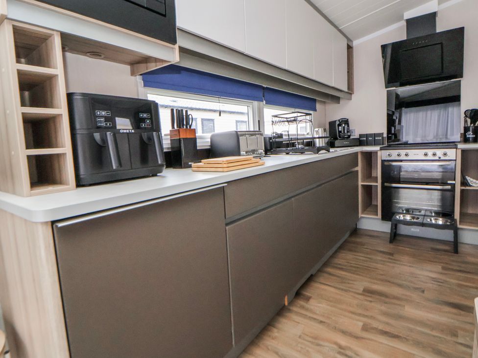 A kitchen with appliances and a counter at Chappie's Caravan 2.0 in Rhyl