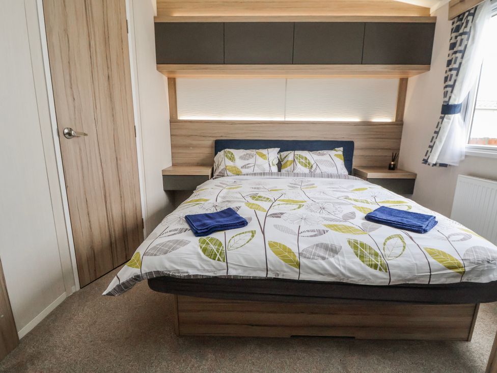 A bedroom with a bed and towels on the linens at Chappie's Caravan 2.0 in Rhyl