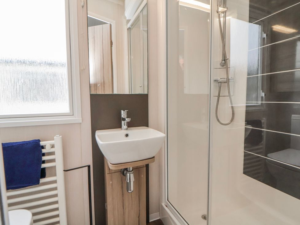 A bathroom with a sink and shower at Chappie's Caravan 2.0 in Rhyl