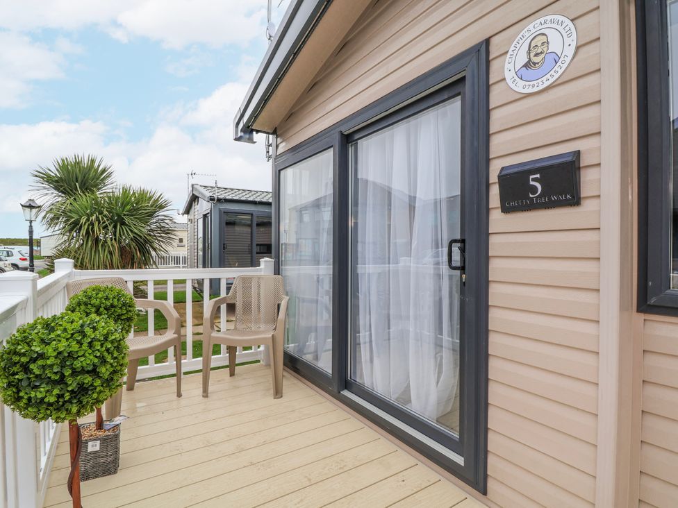 An outdoor area with chairs and a potted plant at Chappie's Caravan 2.0 in Rhyl