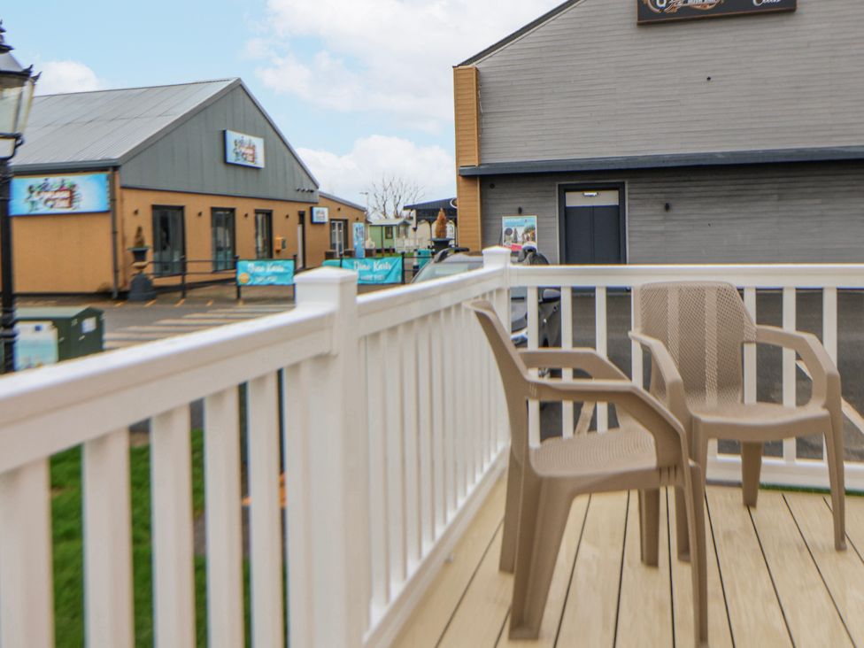 An outdoor area with chairs and a railing at Chappie's Caravan 2.0 in Rhyl