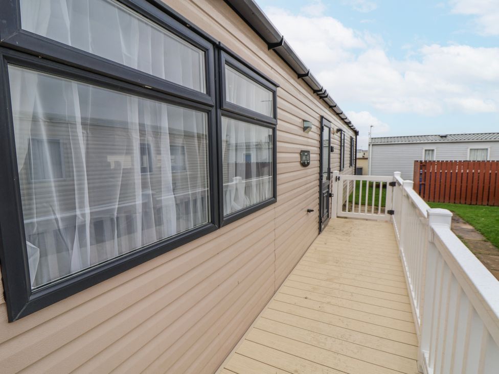 An outdoor area with a deck and windows at Chappie's Caravan 2.0 in Rhyl