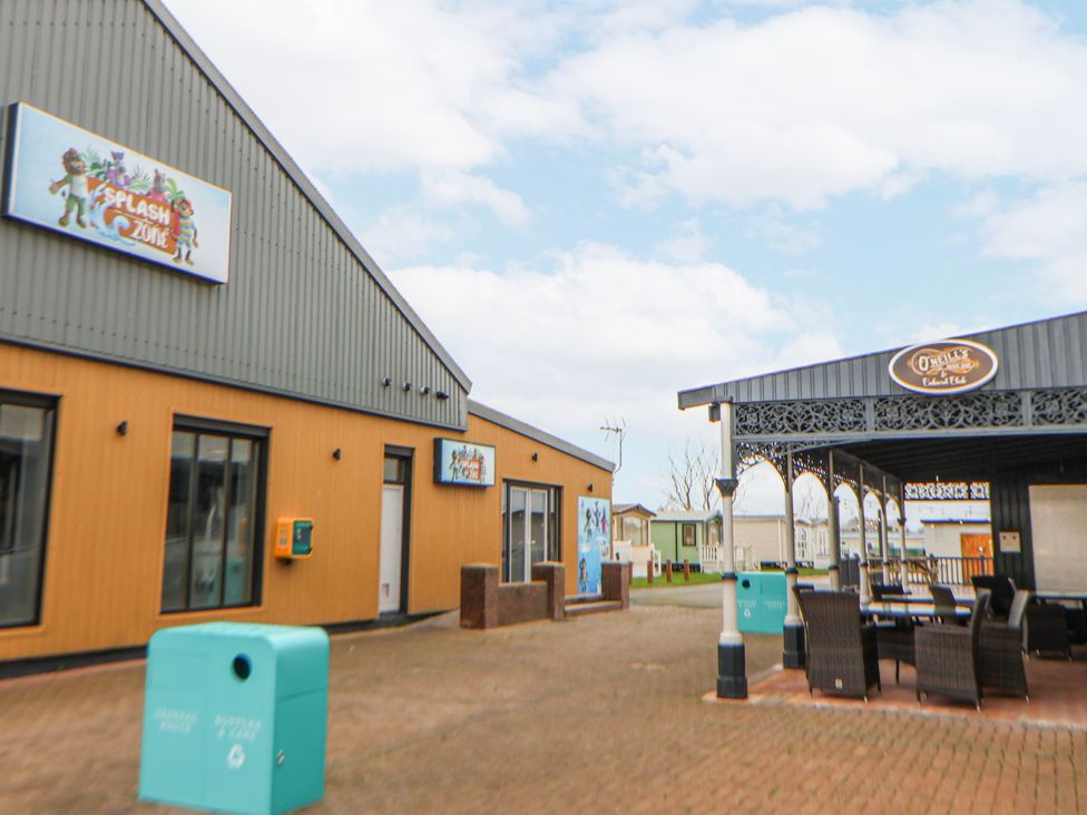 An outdoor area with buildings and seating at Chappie's Caravan 2.0 in Rhyl