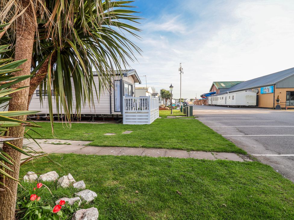 An outdoor view of a caravan beside a parking lot at Chappie's Caravan 2.0 in Rhyl