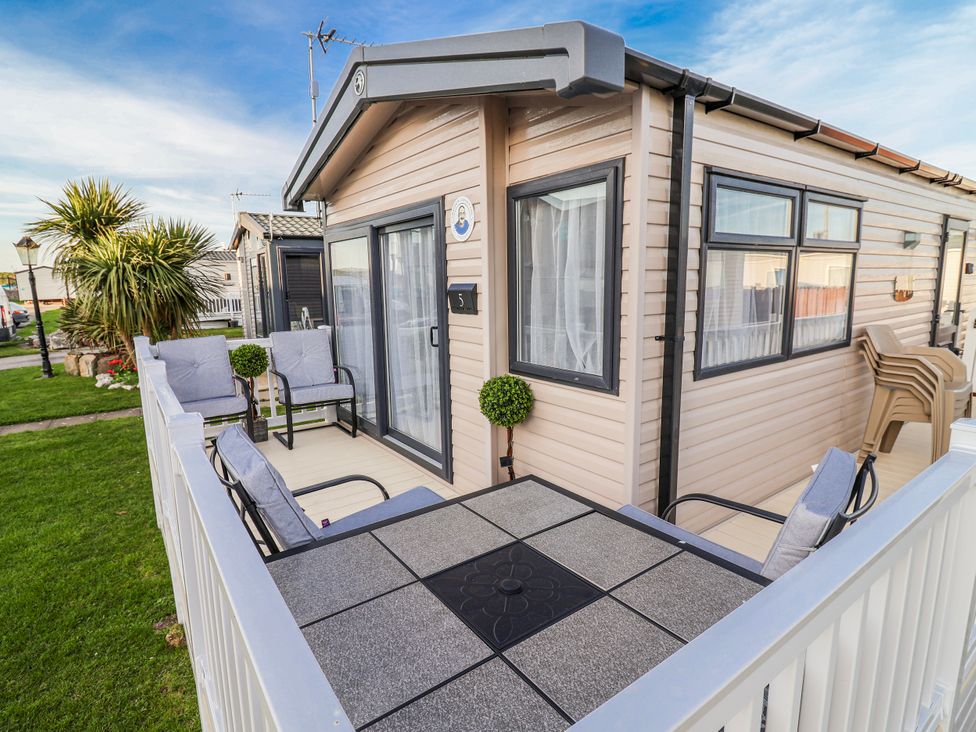 An outdoor seating area with chairs and a table at Chappie's Caravan 2.0, Rhyl