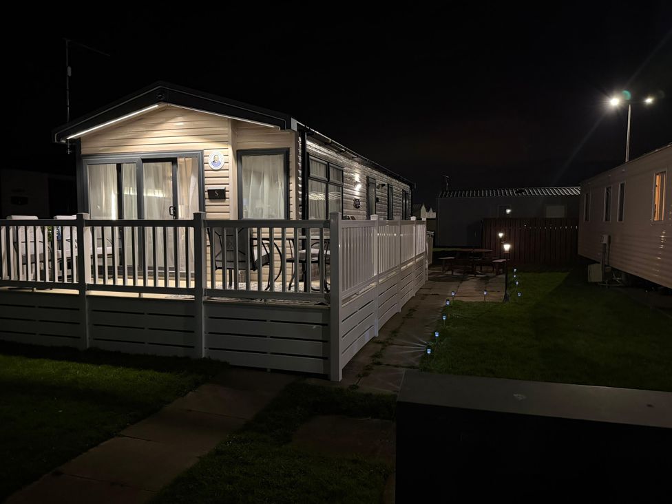 A caravan with decking and outdoor seating at Chappie's Caravan 2.0 Rhyl