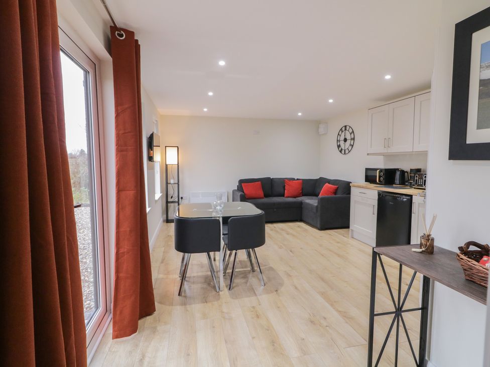 A living room with a sofa and dining table at Binevenagh Point Cabin