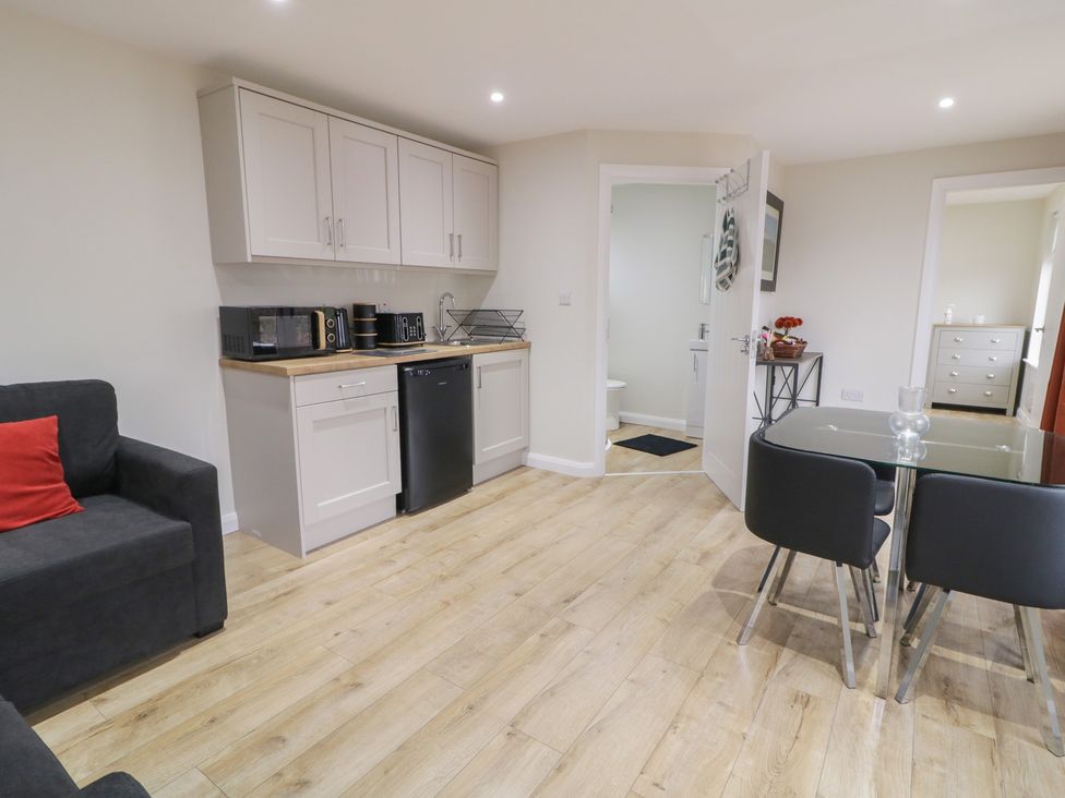 A kitchen with a refrigerator, microwave, and dining table at Binevenagh Point Cabin