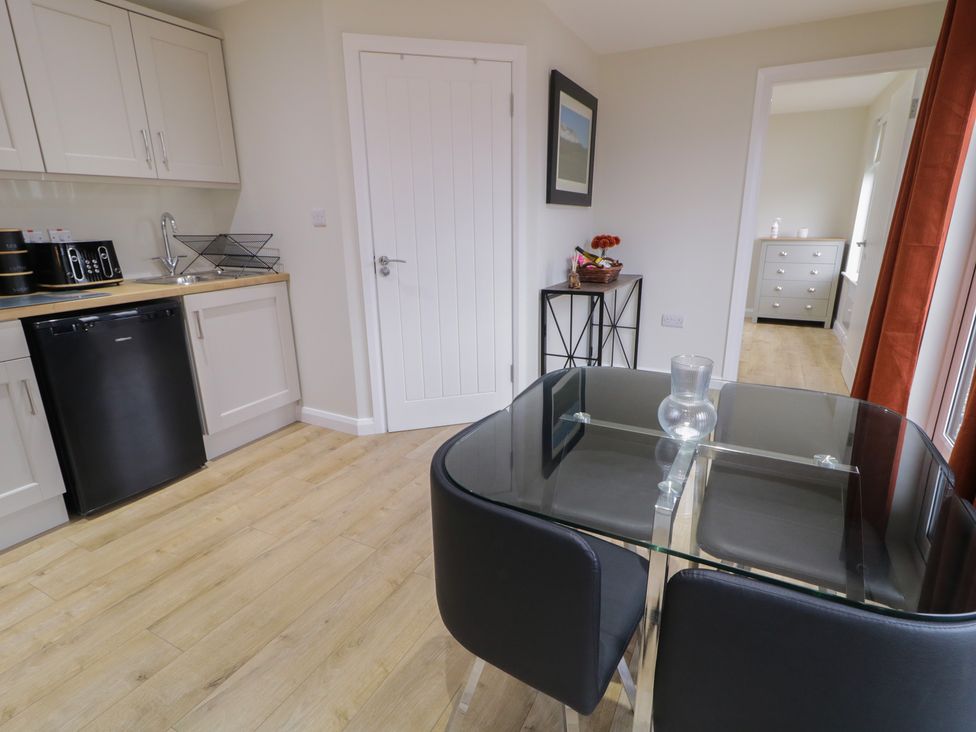 A kitchen with a table and chairs at Binevenagh Point Cabin 