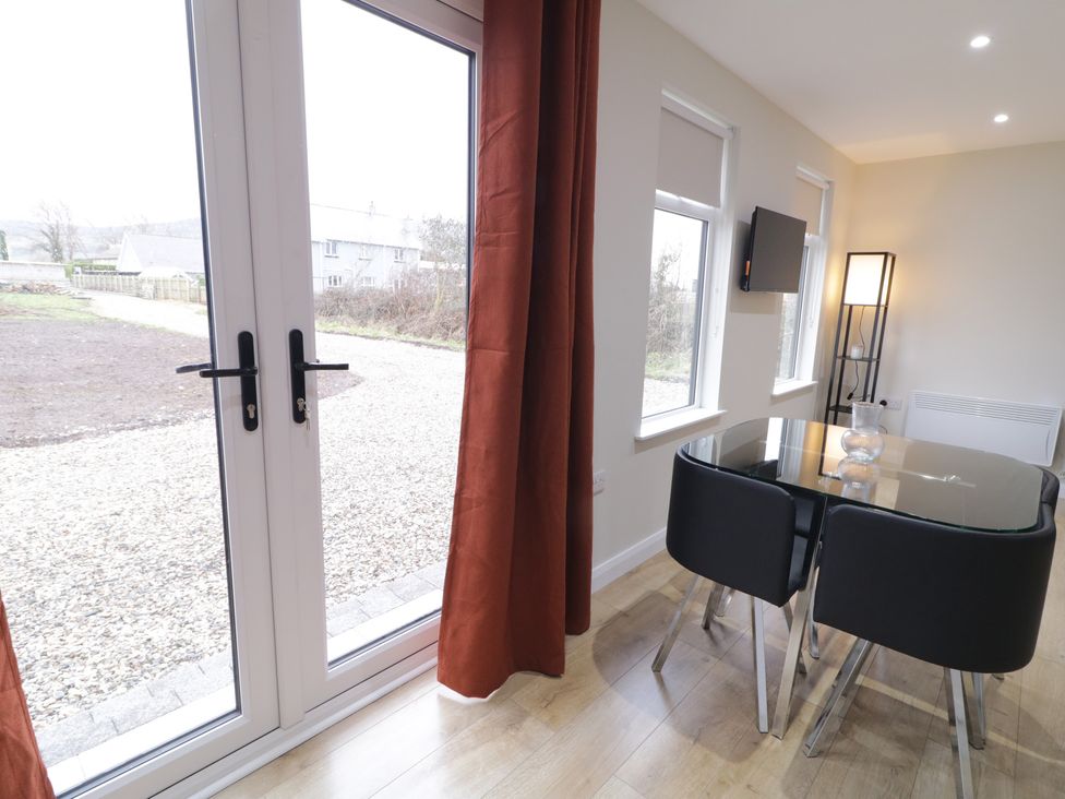 A dining room with a table and chairs at Binevenagh Point Cabin 