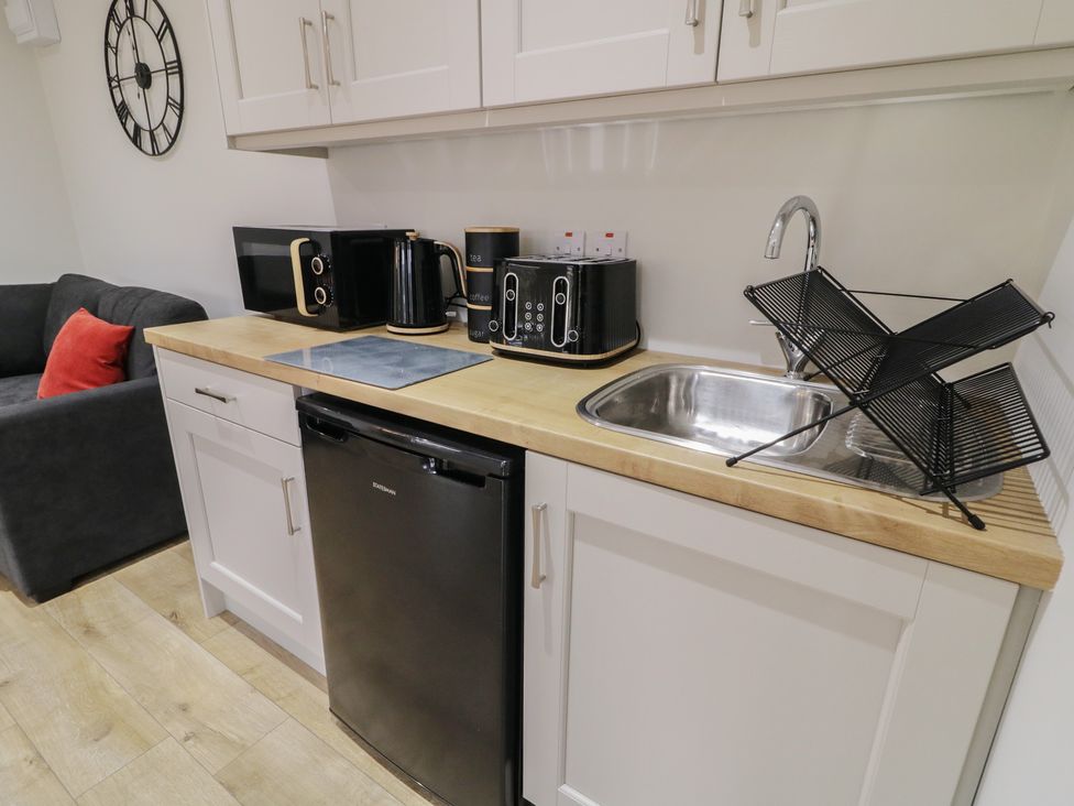 A kitchen with appliances including a microwave, kettle, and toaster at Binevenagh Point Cabin