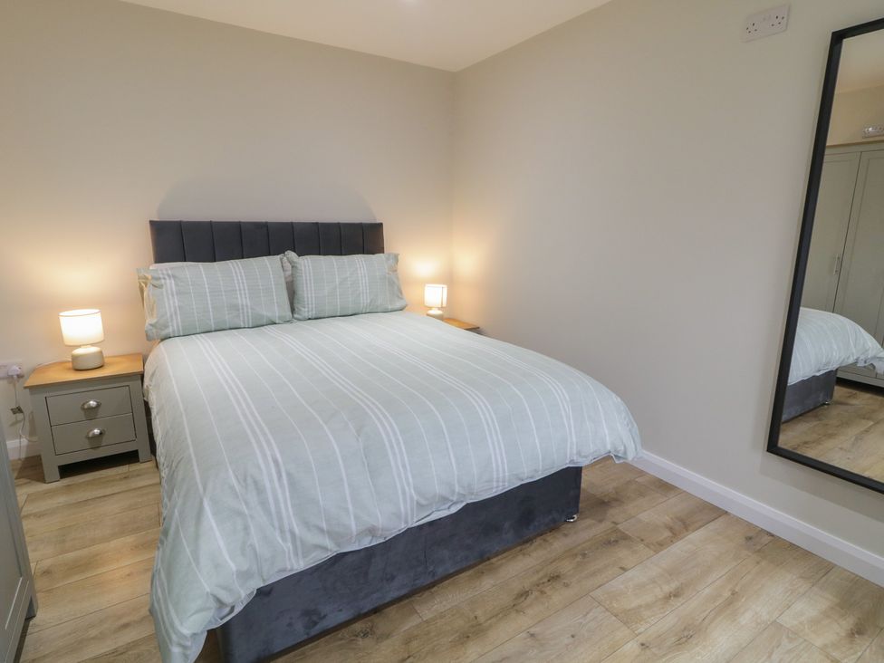 A bedroom with a bed and bedside tables at Binevenagh Point Cabin