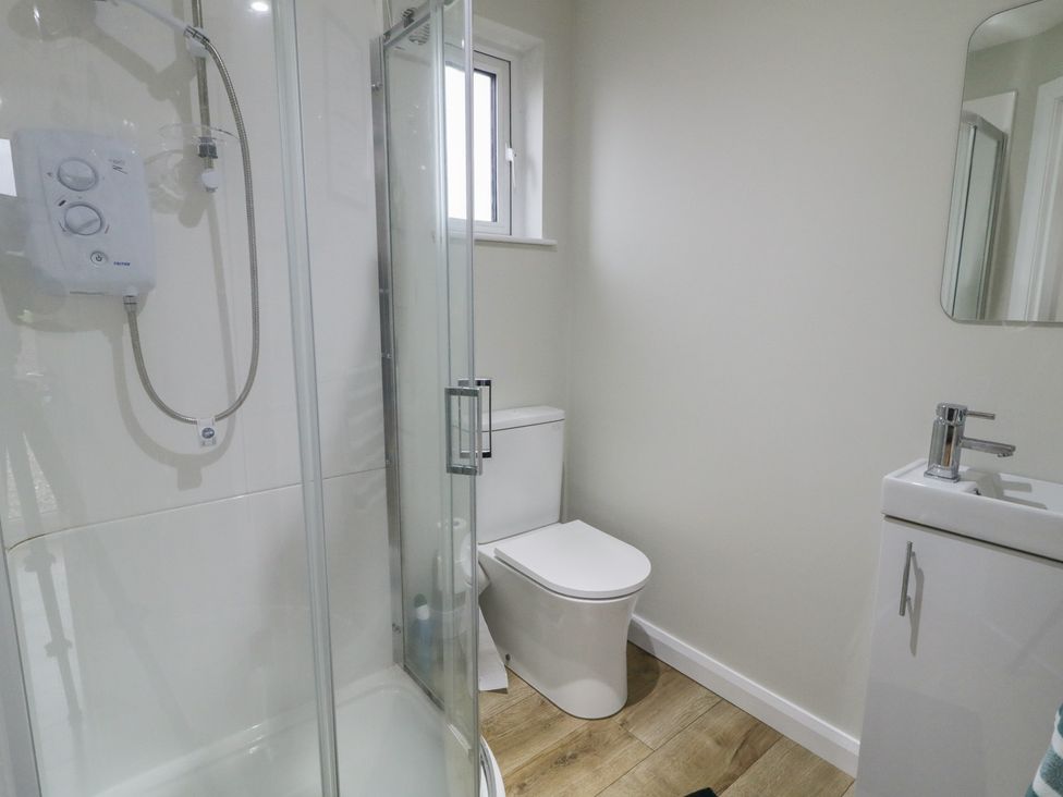A bathroom with a shower, toilet, and sink at Binevenagh Point Cabin
