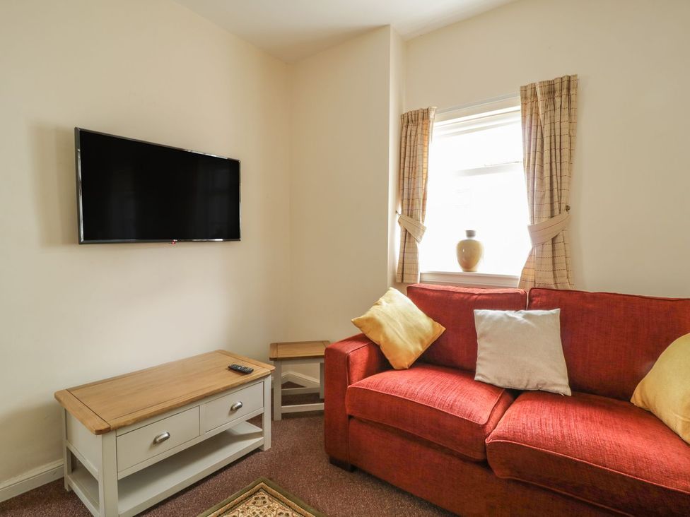 A living room with a television and sofa at No 8- Farmhouse Retreat in Keswick