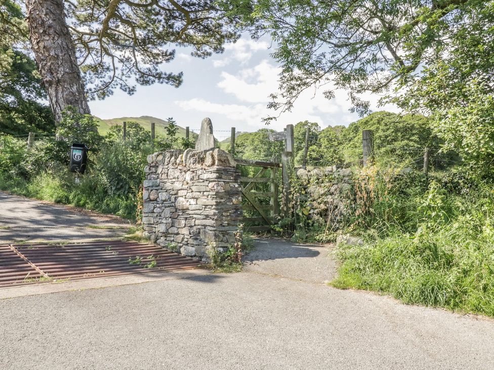 A stone wall and gate by a green area at No 8- Farmhouse Retreat in Keswick