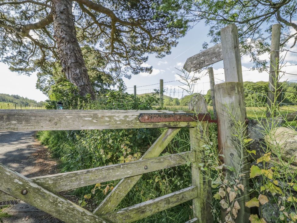 An outdoor scene featuring a wooden gate and a signpost at No 8- Farmhouse Retreat in Keswick