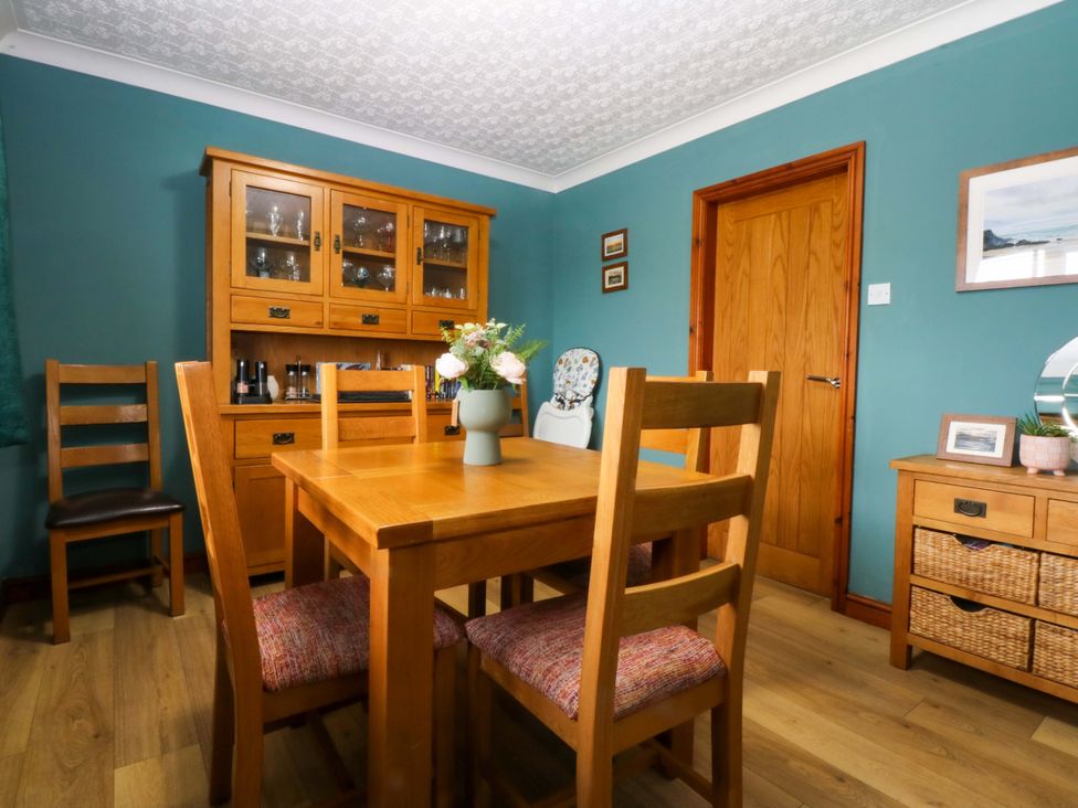 A dining room with a table and chairs at 36 Cae Rhos in Holyhead