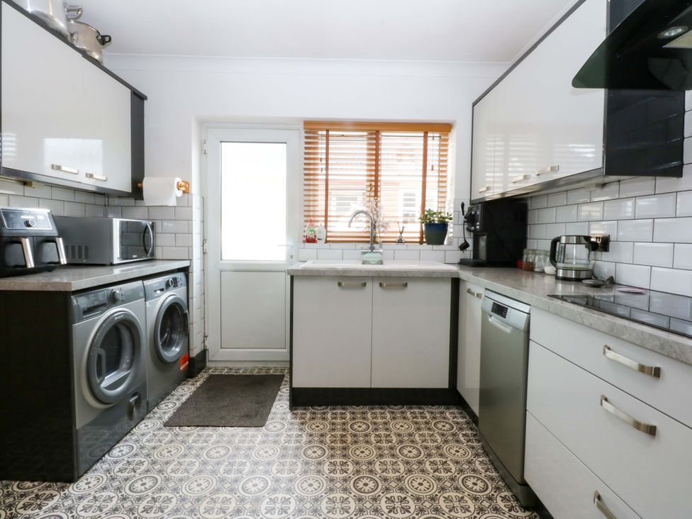 A kitchen with washing machine and dryer at 36 Cae Rhos Holyhead