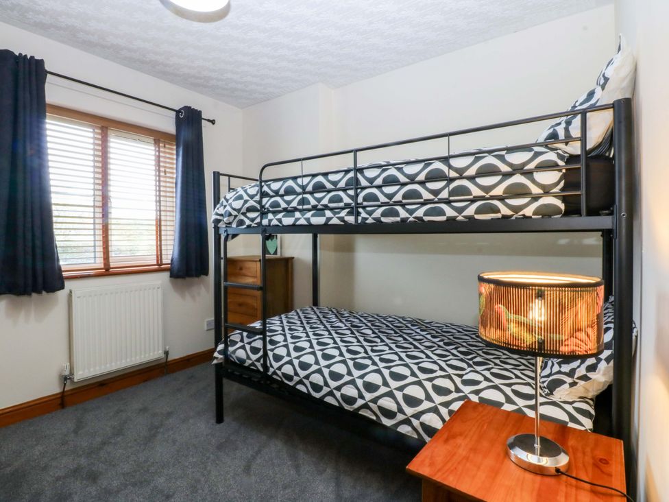 A bedroom with a bunk bed and lamp at 36 Cae Rhos in Holyhead