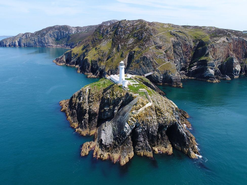 A lighthouse situated on a rocky island surrounded by water at 36 Cae Rhos Holyhead