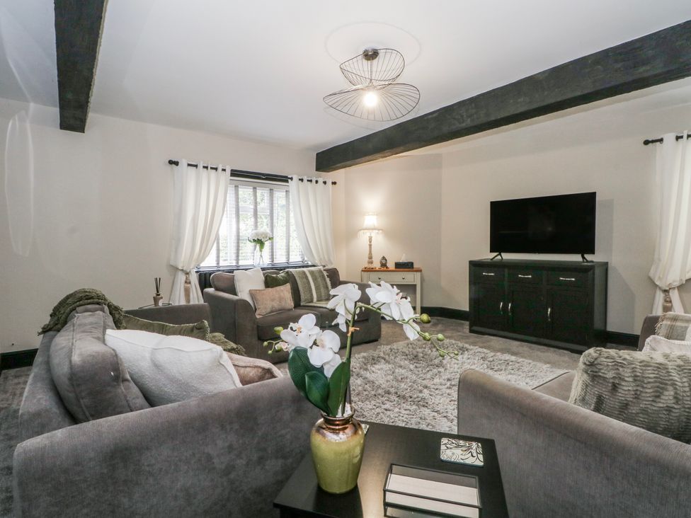 A living room with a sofa, armchairs, and a television at 2 Manor House farm, Higher Ogden near Newhey