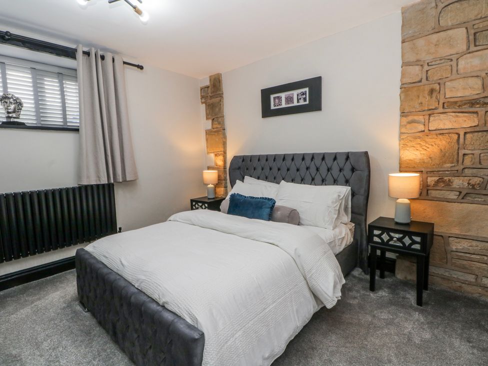 A bedroom with a bed and nightstands at 2 Manor House farm Higher Ogden near Newhey