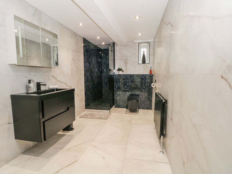 A bathroom with a sink, shower, and toilet at 2 Manor House farm Higher Ogden near Newhey