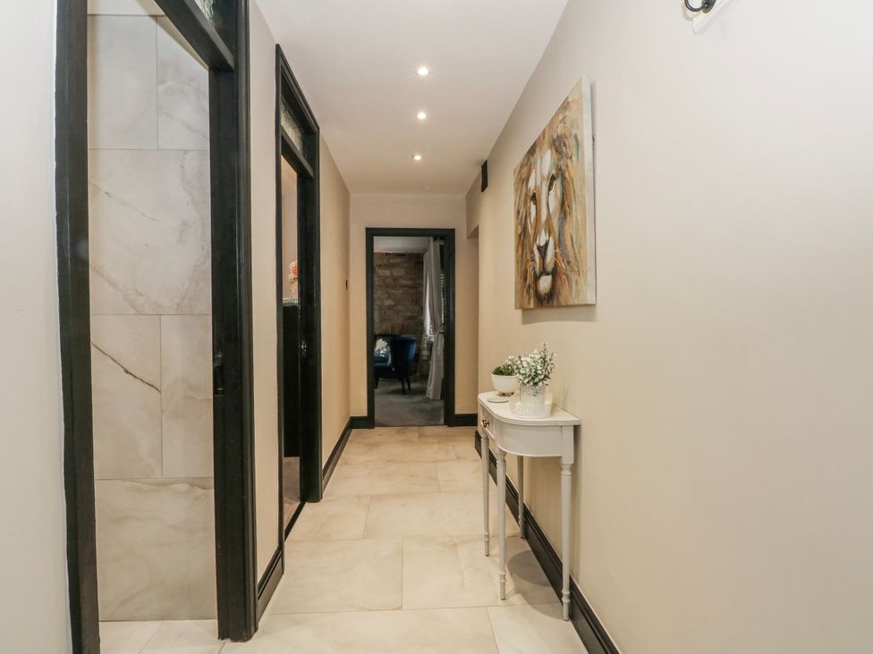 A hallway with a painting and a console table at 2 Manor House farm Higher Ogden near Newhey