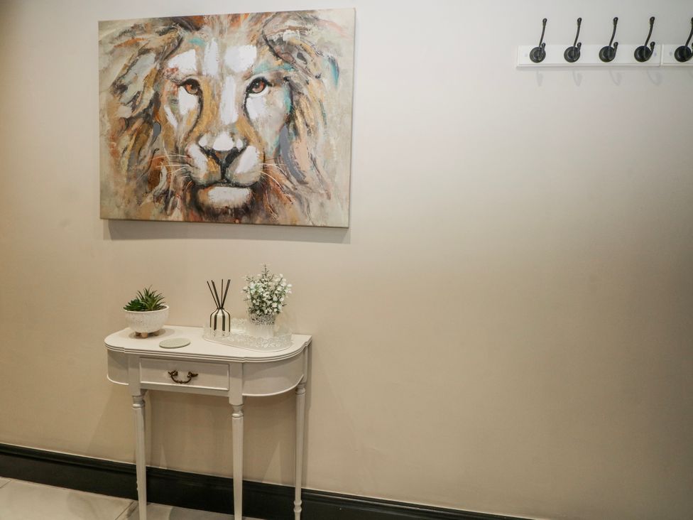 A hallway with a lion painting and a console table at 2 Manor House farm Higher Ogden near Newhey