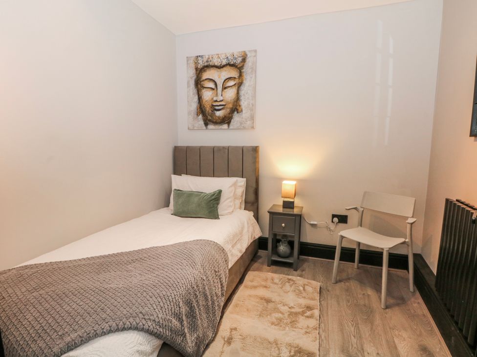 A bedroom with a single bed and lamp at 2 Manor House farm Higher Ogden near Newhey