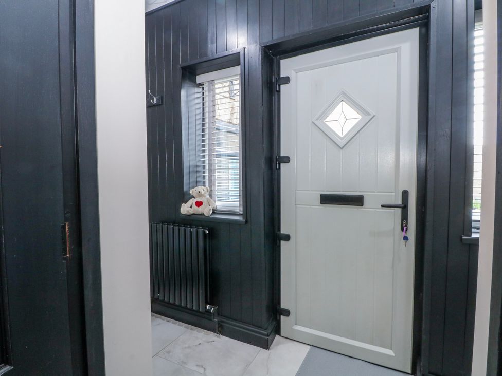 An entryway with a front door and a teddy bear at 2 Manor House farm Higher Ogden near Newhey