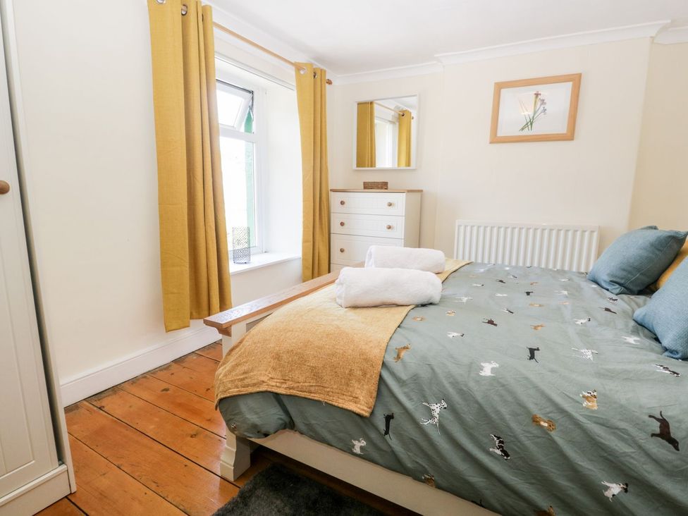 A bedroom with a bed and dresser at Yewbarrow in Seascale