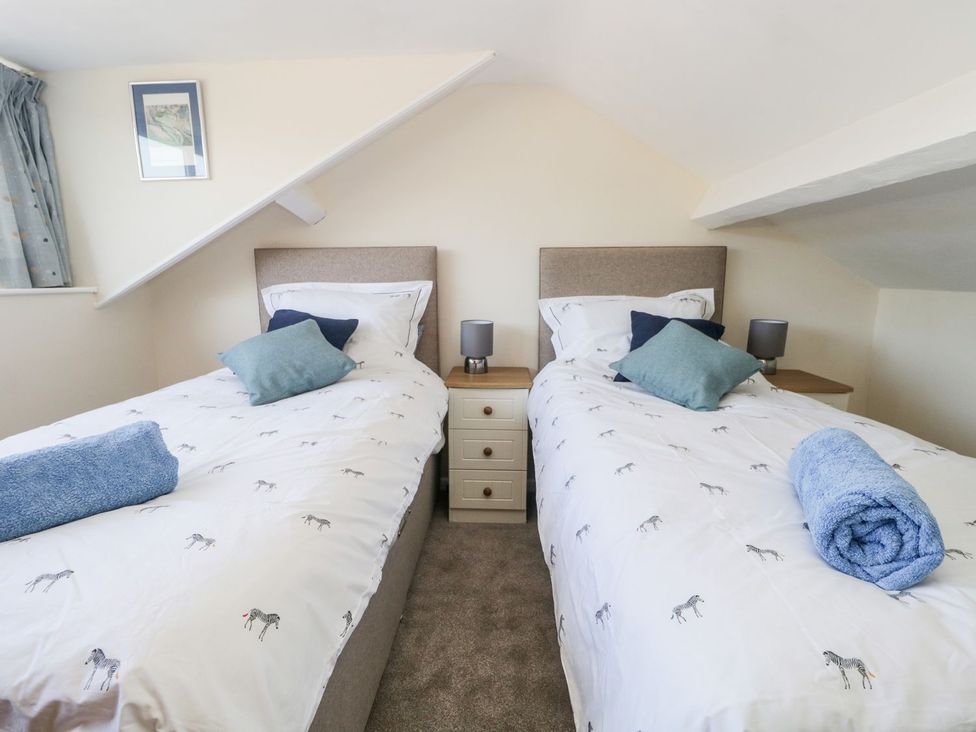 A bedroom with two single beds and a drawer unit at Yewbarrow Seascale