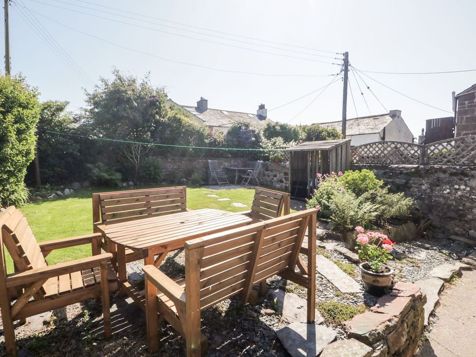 A garden with a wooden table and chairs at Yewbarrow Seascale