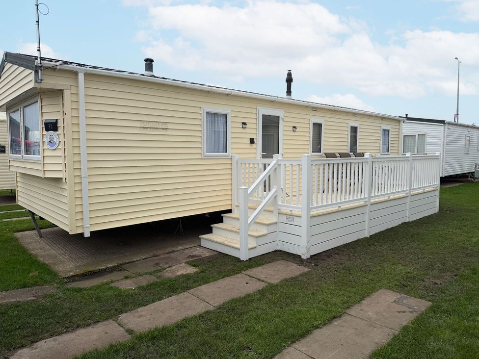 A caravan with a deck and stairs at Chappie's Caravan in Rhyl