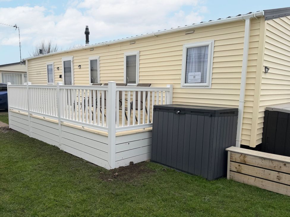 An outdoor area with a caravan and deck at Chappie's Caravan in Rhyl